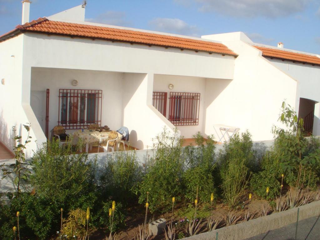 a white house with a fence in front of it at Barracudamaio in Morro