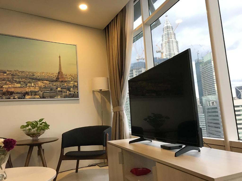 sala de estar con TV de pantalla plana grande frente a una ventana en VORTEX SUITES KLCC by PNUT With NETFLIX, en Kuala Lumpur