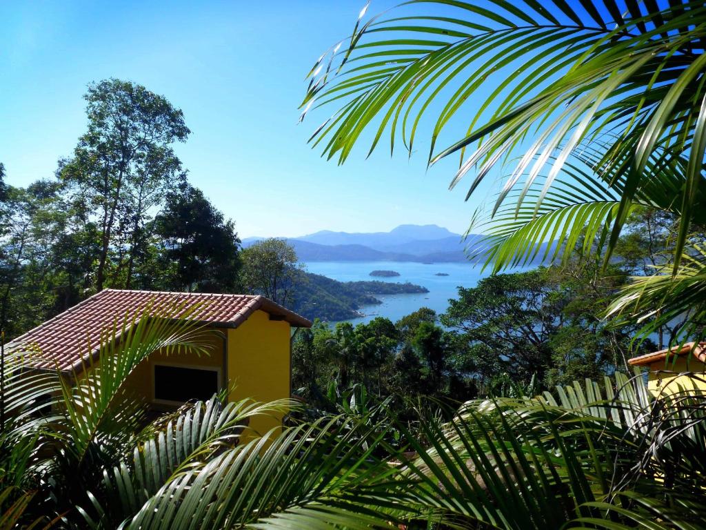 a yellow house with a view of the water at Bus Stop Paraty in Paraty