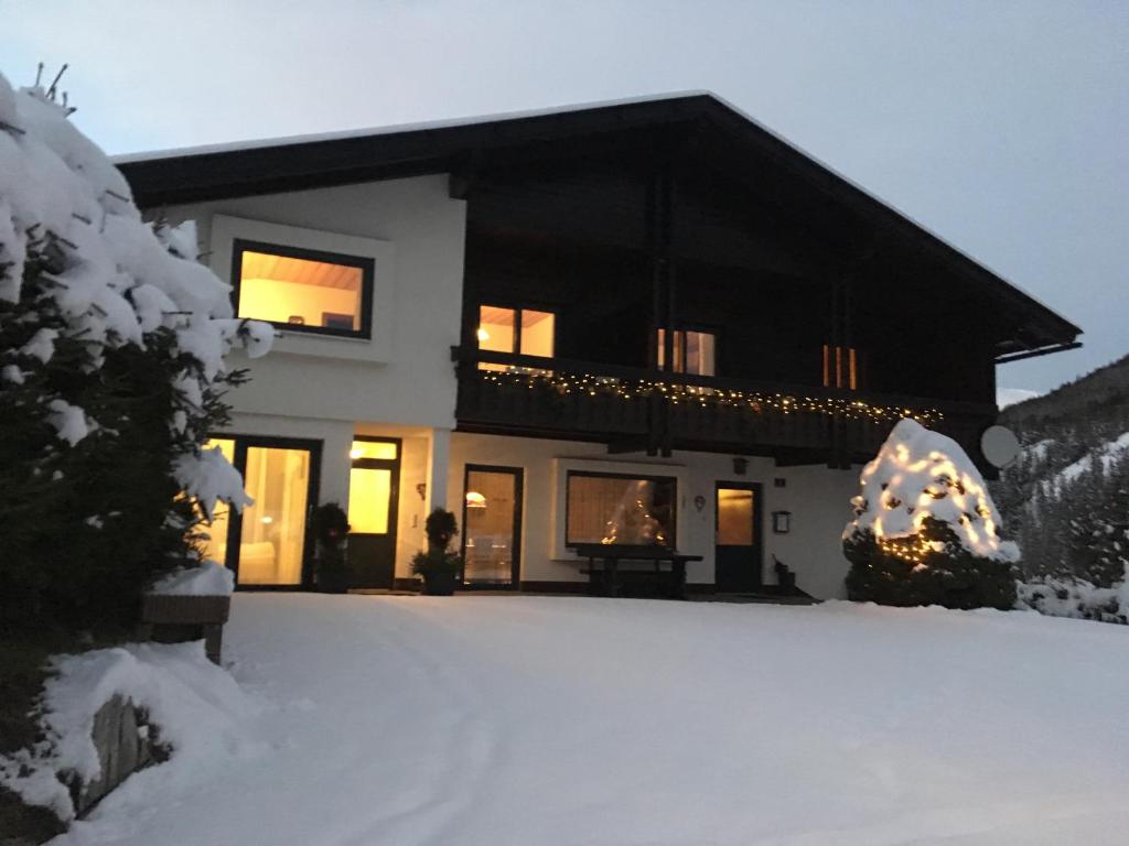 Una casa en la nieve con luces de Navidad en Appartement Latschen - Ferienhaus, en Bad Kleinkirchheim