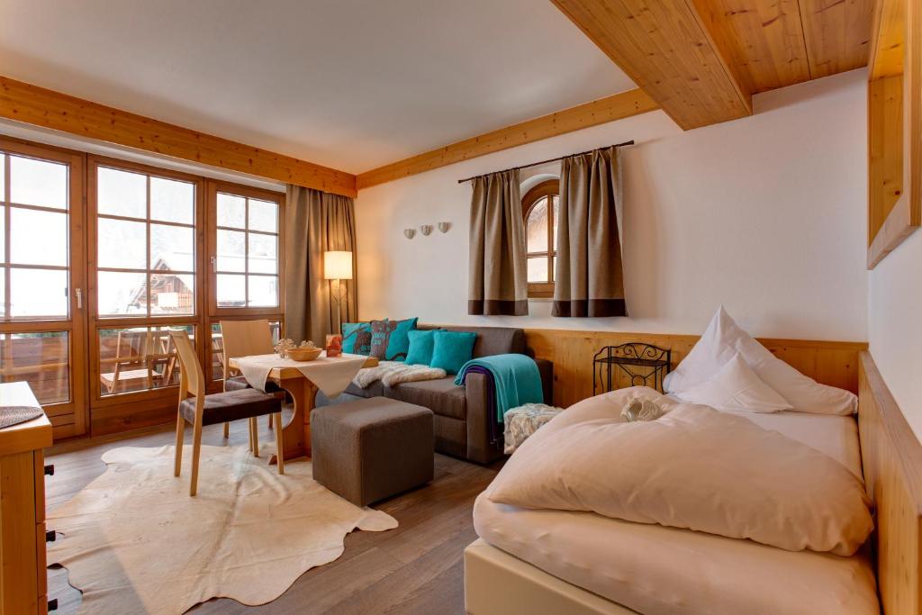 a bedroom with a bed and a living room at Am Dorfplatz Suites - Adults only in Sankt Anton am Arlberg