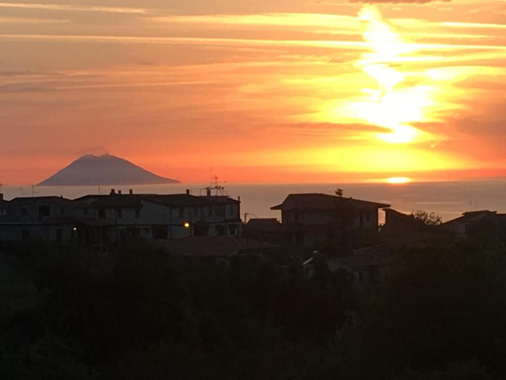 una puesta de sol sobre una ciudad con una montaña en el fondo en Casa vacanze zaccanopoli, en Zaccanopoli