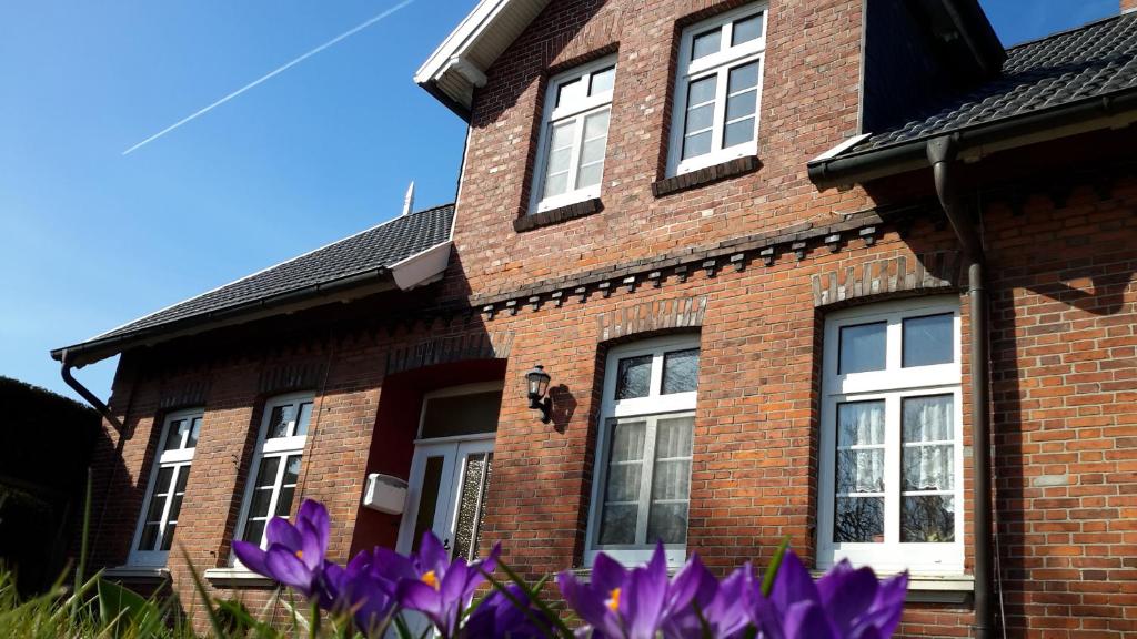 エセンスにあるLandhaus von Feldeの紫の花が咲くレンガ造りの家