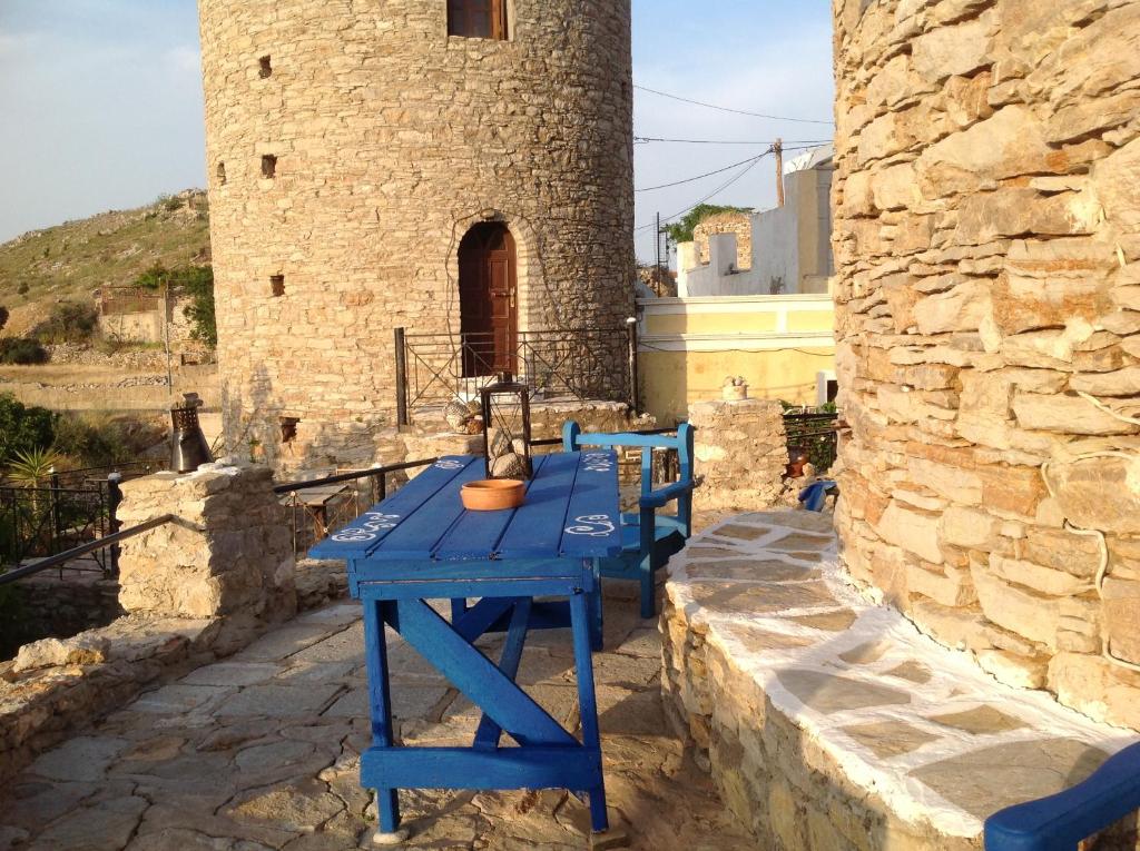 einem blauen Tisch vor einem Steingebäude in der Unterkunft The Windmill in Symi