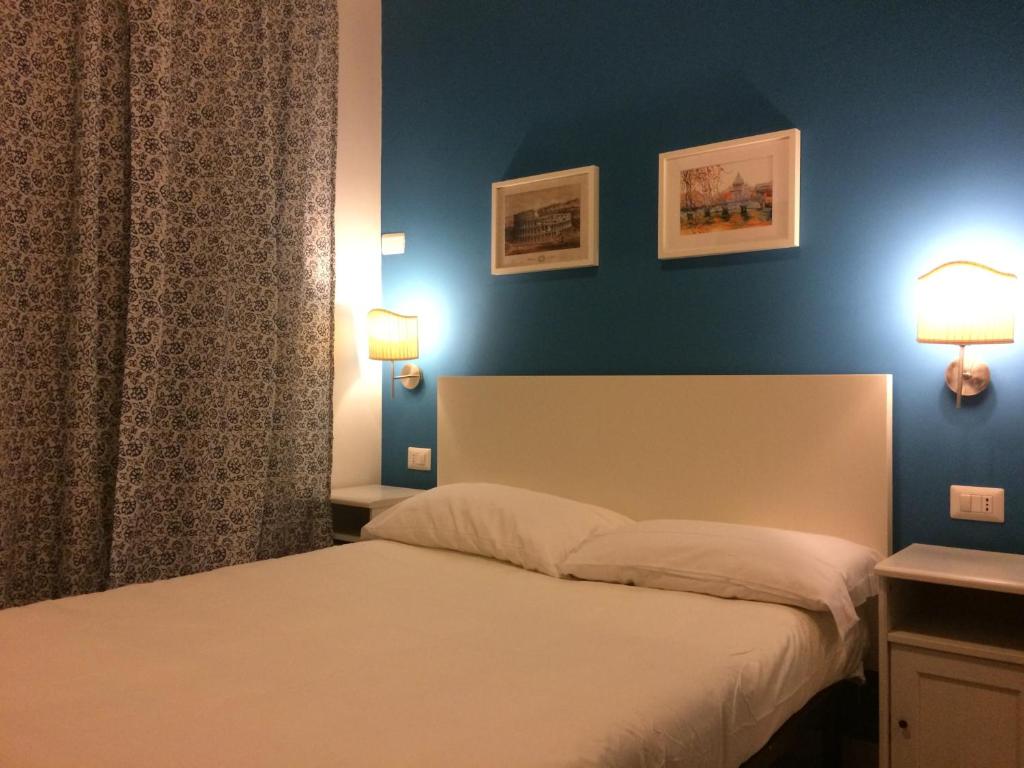 1 dormitorio con cama y pared azul en La Dolce Vita Rome Ciampino, en Ciampino