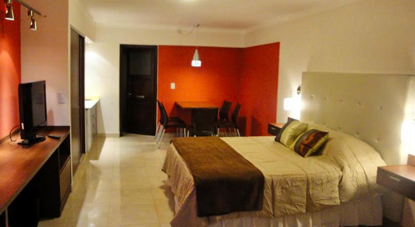 - une chambre avec un lit, une table et une télévision dans l'établissement Casacerro, à Salta