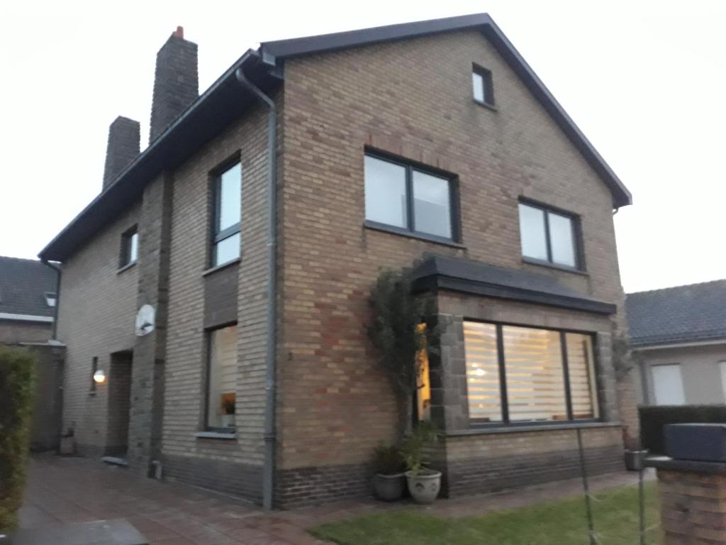una casa de ladrillo con ventanas y entrada en Kamer + douche in villa, en Knokke-Heist