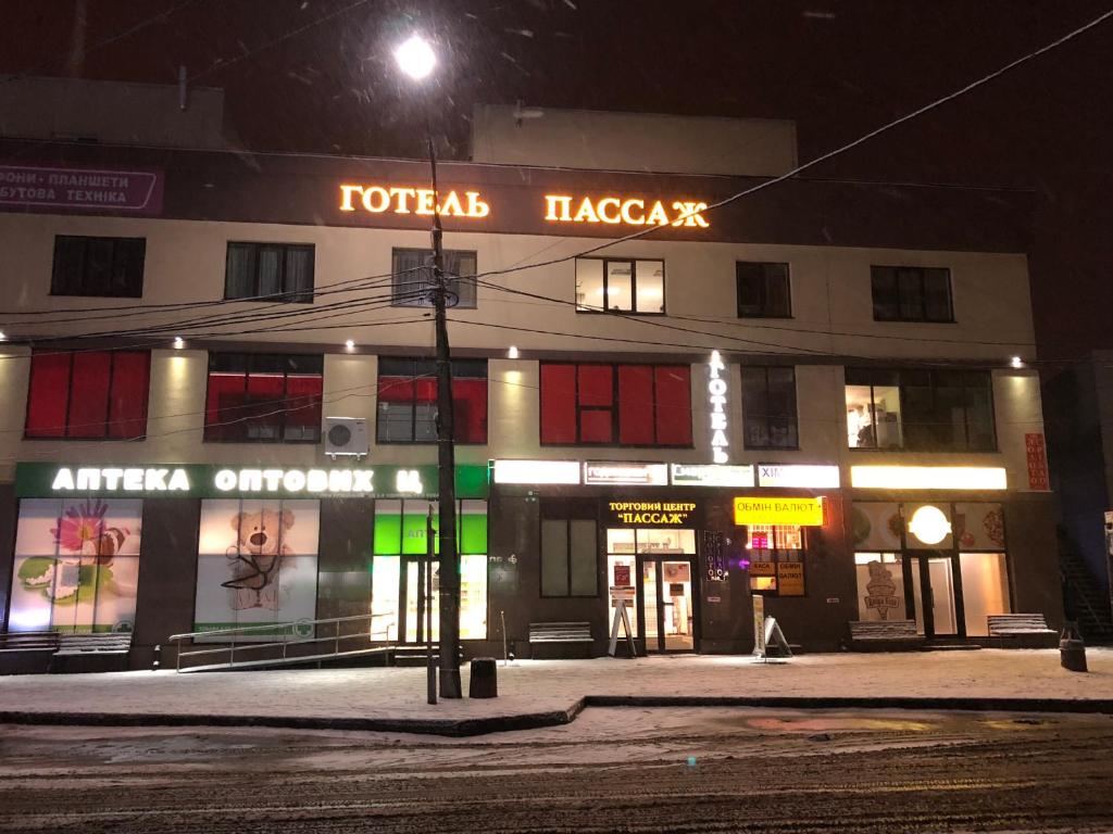 a building on a street corner at night at Passage Hotel in Ternopilʼ