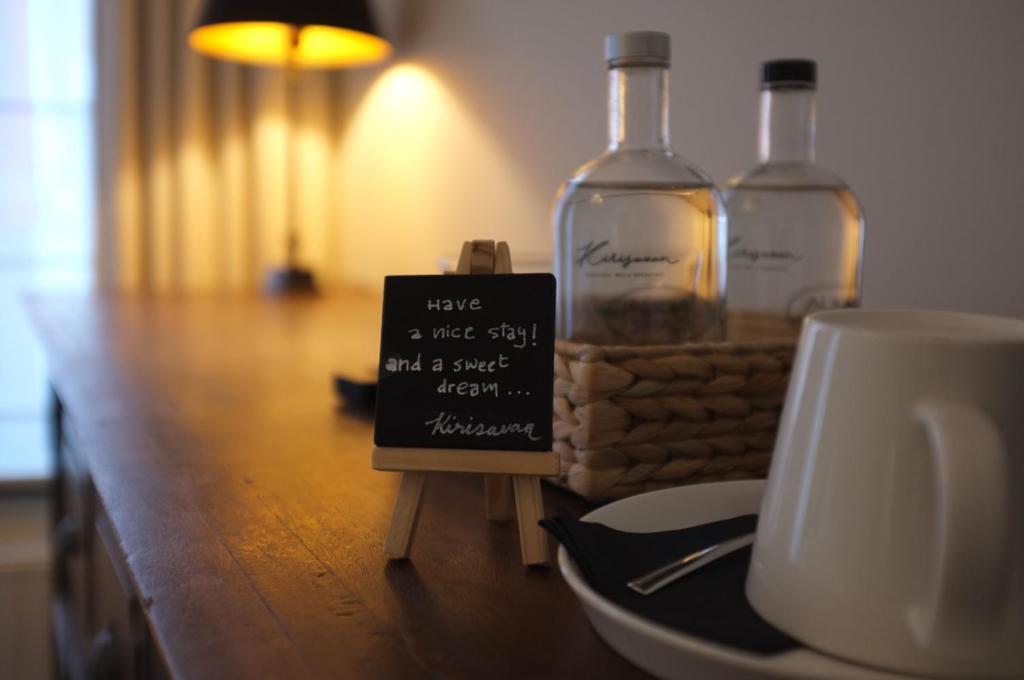 una mesa con dos botellas de alcohol y un cartel encima en Kirisavan Bed&Breakfast, en Borgloon