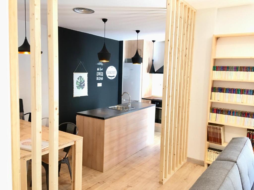 a kitchen and living room with a table and a couch at Apartamento Vive Zaragoza in Zaragoza