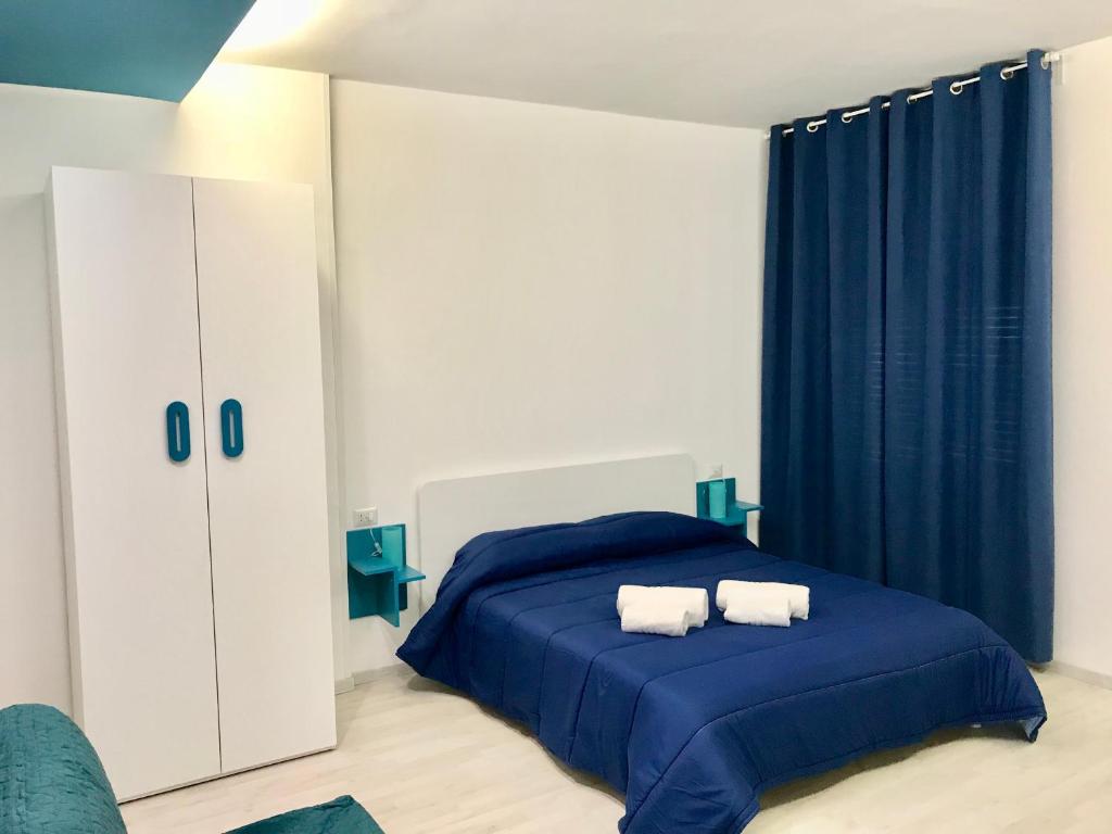 een slaapkamer met een blauw bed en 2 handdoeken bij B&B Fratelli Tommasini Salerno in Salerno