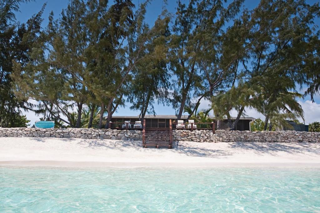 a house on a beach next to a stone wall at Hollywood Beach Suites Turks and Caicos in NCA