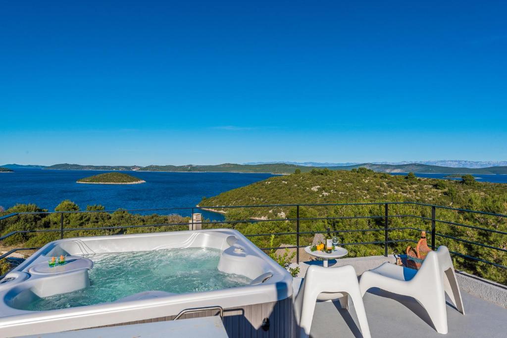 a hot tub on a balcony with a view of the ocean at Villa Kula in Dragove
