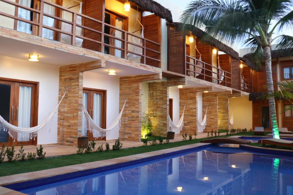 a villa with a swimming pool and a resort at Pousada Jeri Dunas in Jericoacoara