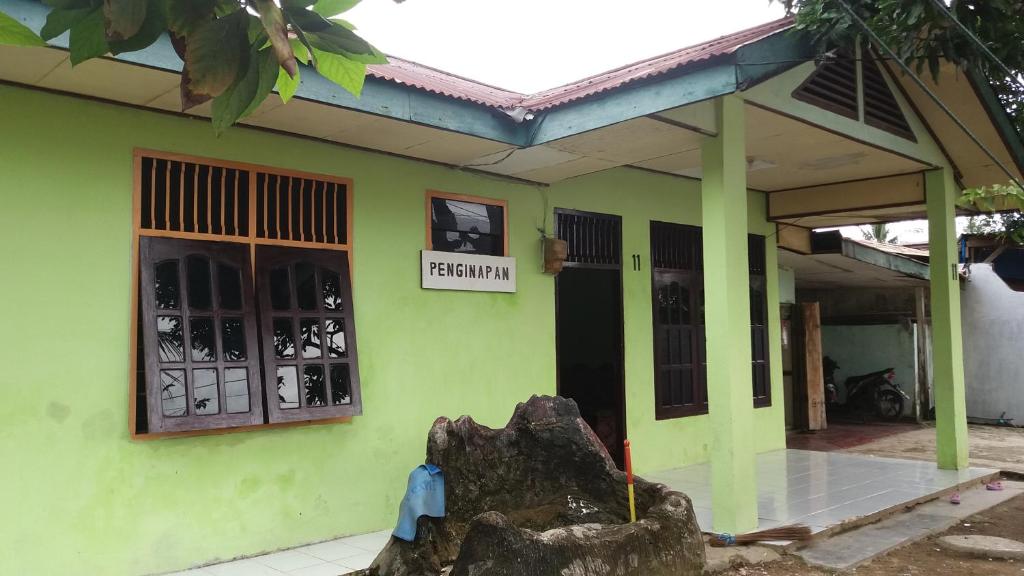 Ein grünes Gebäude mit einem Schild, auf dem der Premier steht. in der Unterkunft Penginapan Kofiyau in Sorong