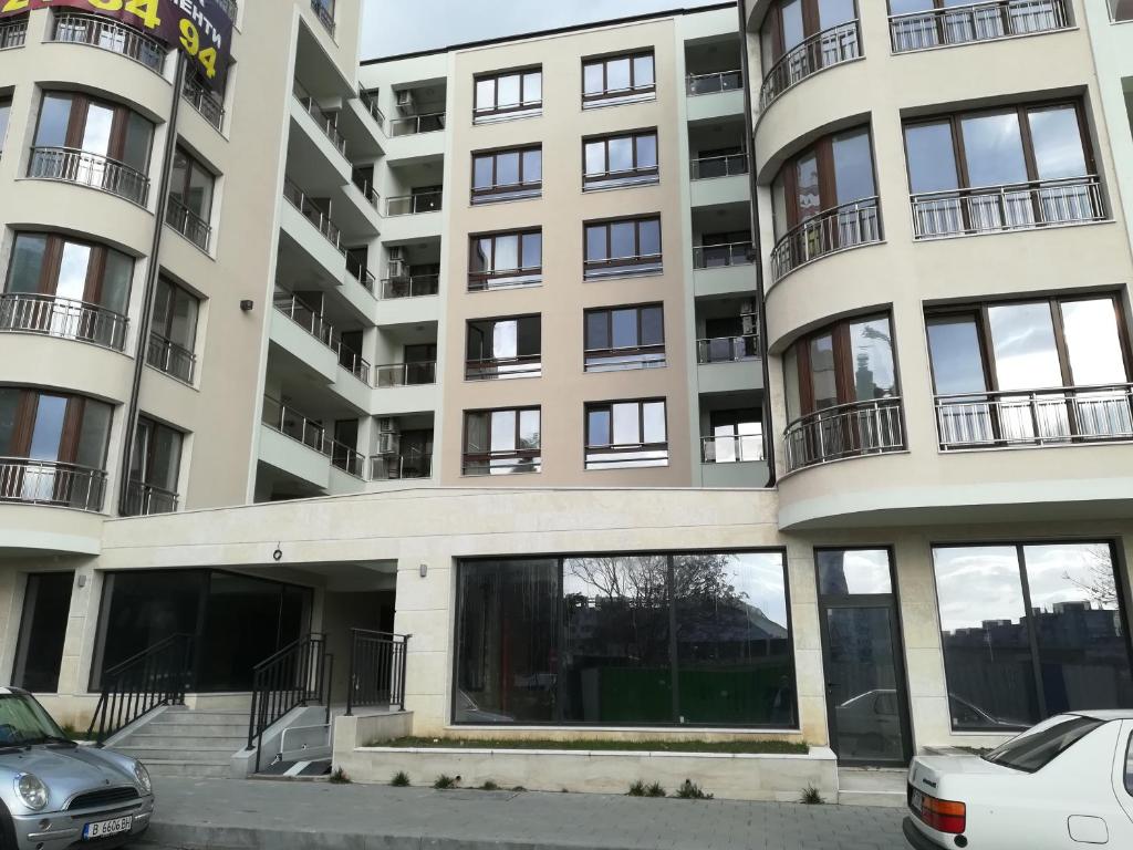 een groot appartementencomplex met auto's voor het gebouw bij Apartment Angelov in Varna