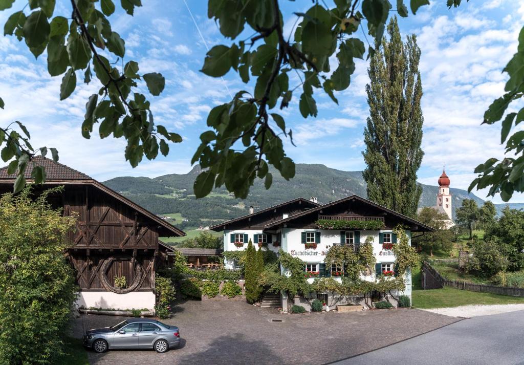 a house with a car parked in front of it at Gasthof Tschötscherhof in Castelrotto