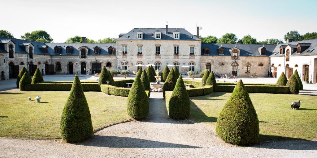 a garden with trees and a large building at Domaine De Barive in Sainte-Preuve