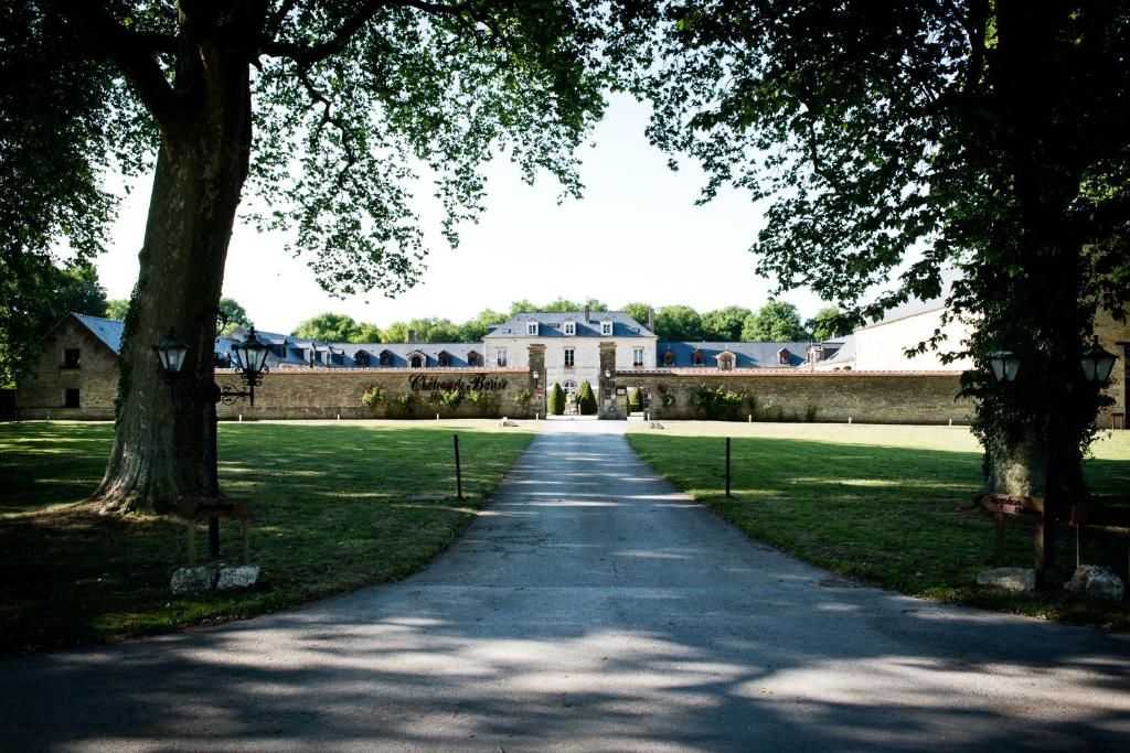 a road leading to a large building with trees at Domaine De Barive in Sainte-Preuve