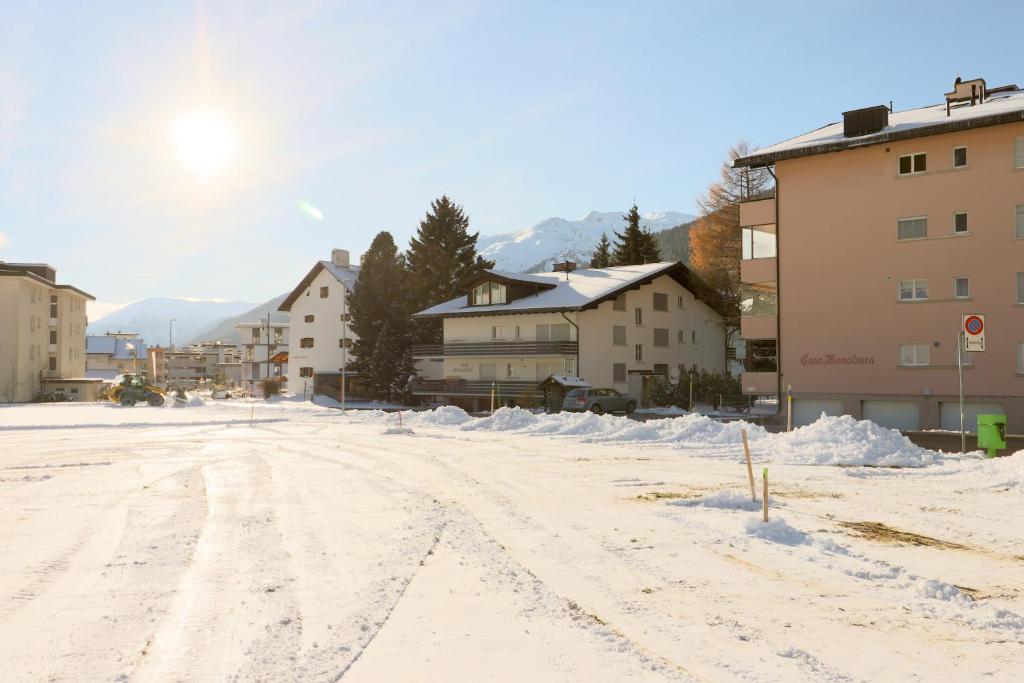 eine schneebedeckte Straße in einer Stadt mit Gebäuden in der Unterkunft Haus Pramalinis - Mosbacher in Davos