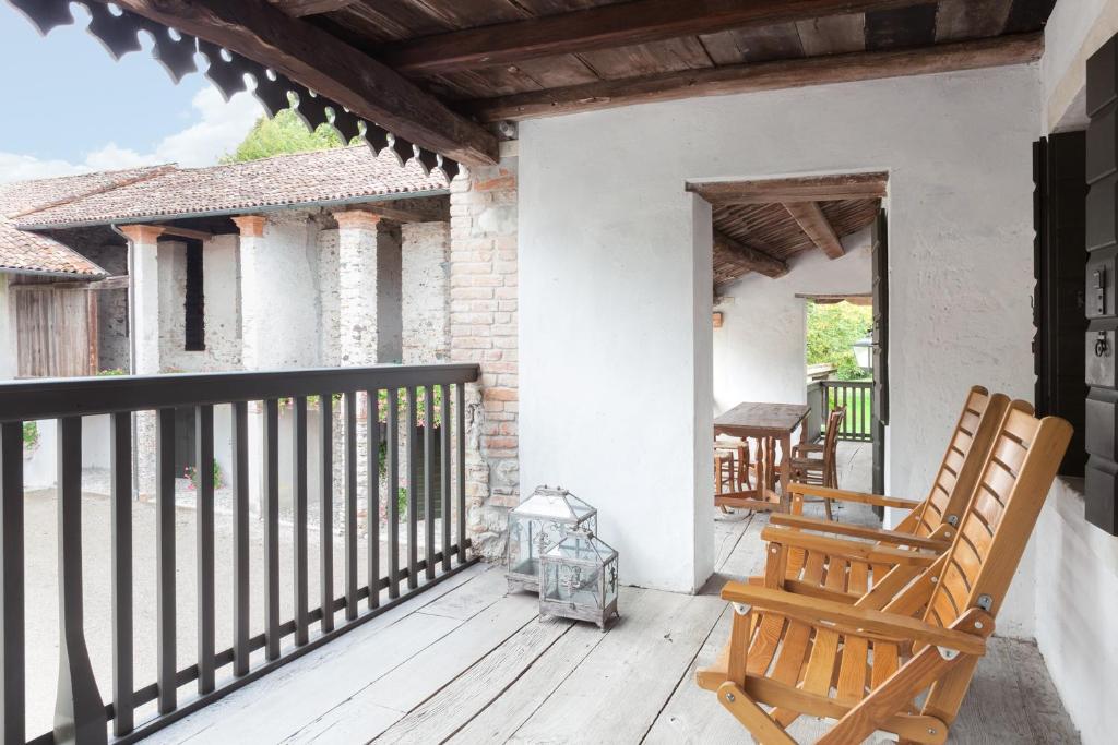 une terrasse couverte avec 2 fauteuils à bascule sur une maison dans l'établissement Colvago La Corte Spectacular Ancient Country House, à Santa Giustina