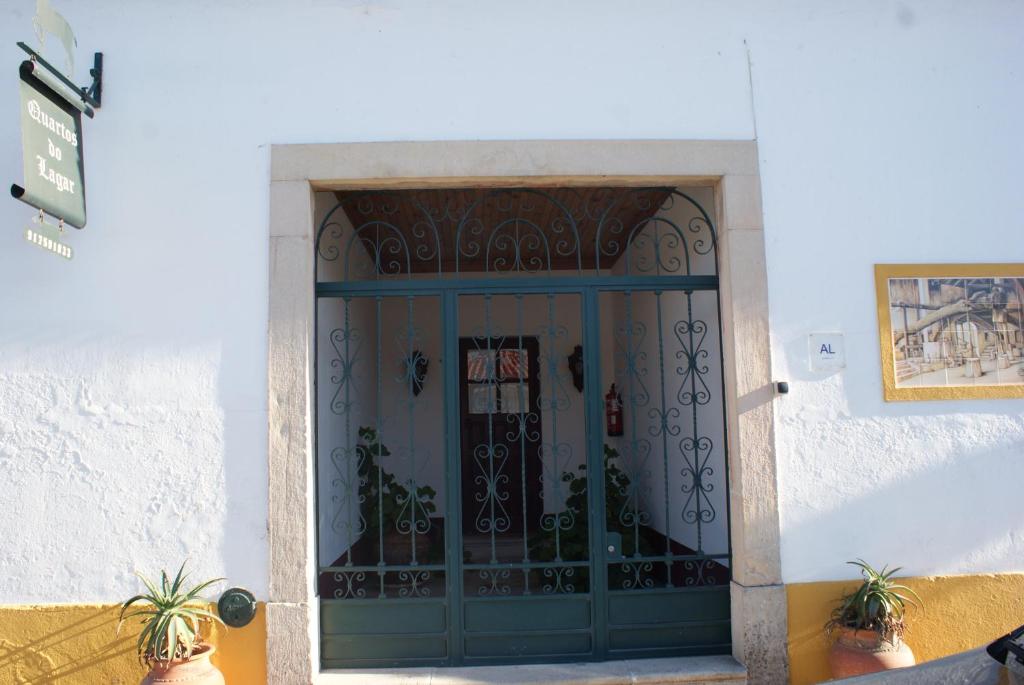 uma porta azul com um portão num edifício em Quartos do Lagar na Golegã