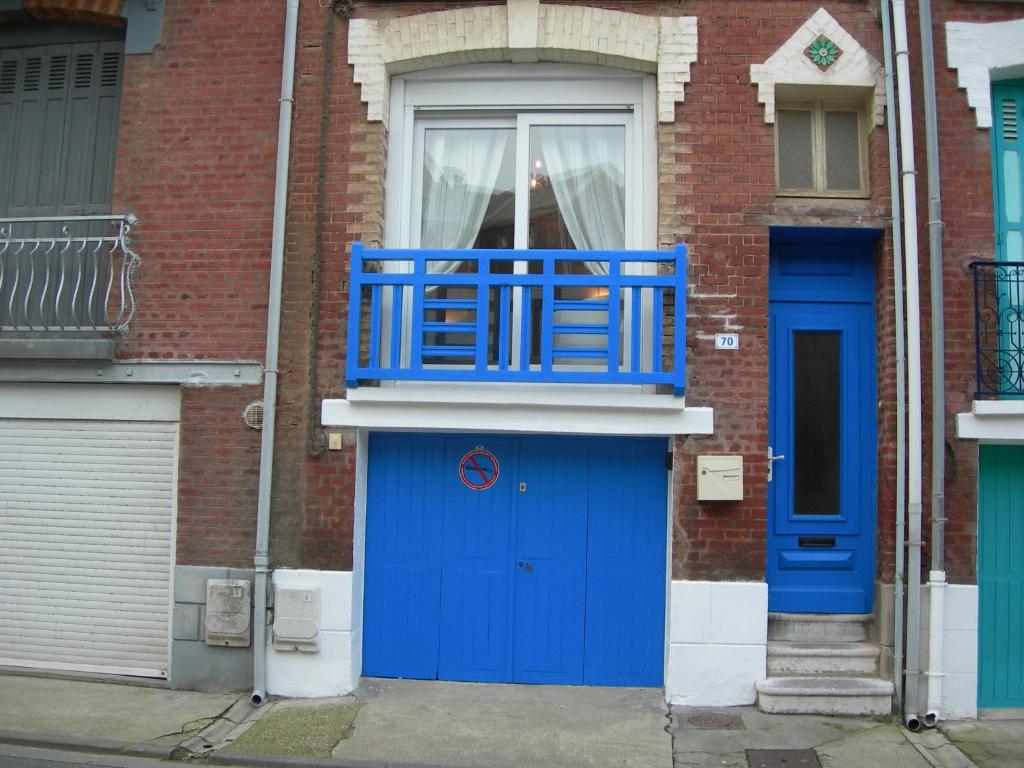 un edificio con una puerta azul y una ventana en Studio la mésange, en Mers-les-Bains