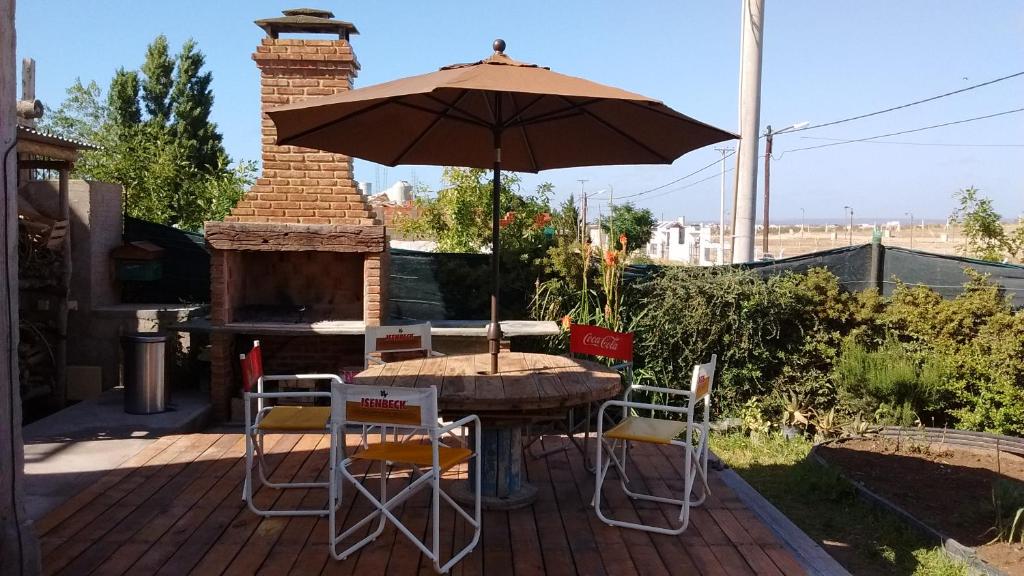 una mesa y sillas con una sombrilla en el patio en Maryfer en Las Grutas