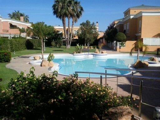 a large swimming pool in a apartment complex at Bungalow cerca de la playa in Alicante