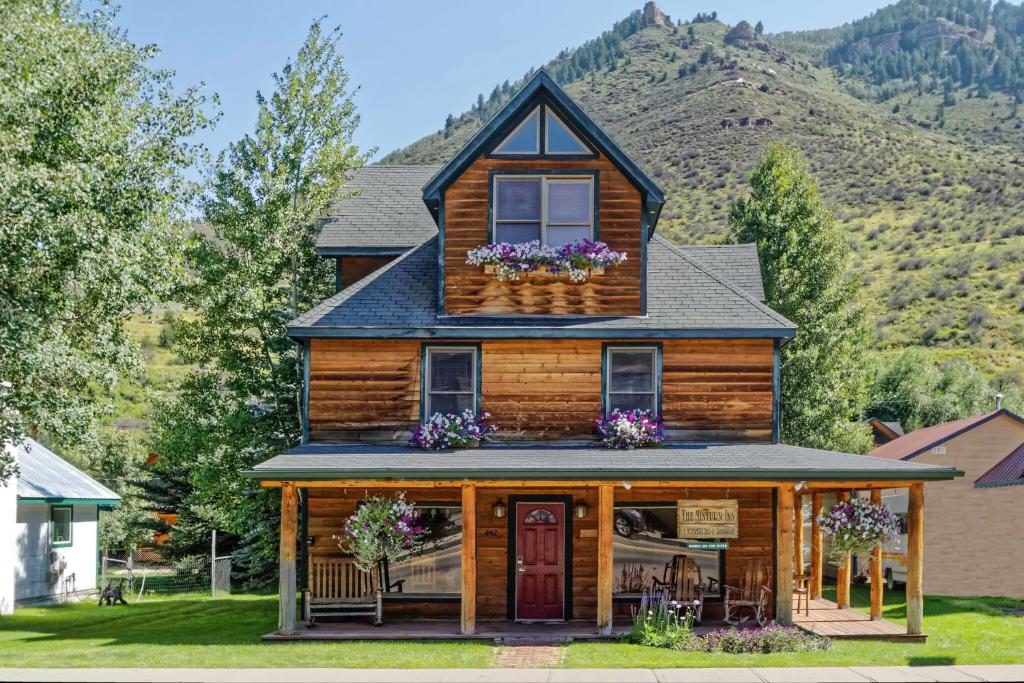a wooden house with flowers in the window at Minturn Inn in Minturn