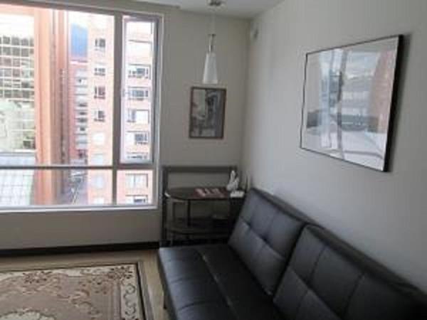 sala de estar con sofá y ventana en Carolina Family Suite, en Quito
