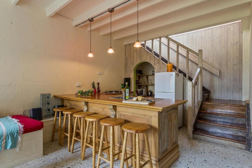 a kitchen with a large wooden counter with stools at Salty Dog by the Sea - Pet Friendly in Rye