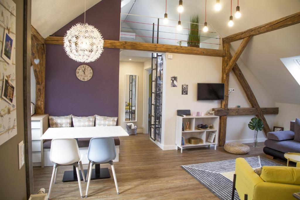 a dining room and living room with a white table and chairs at Zsinkó Villa in Pécs