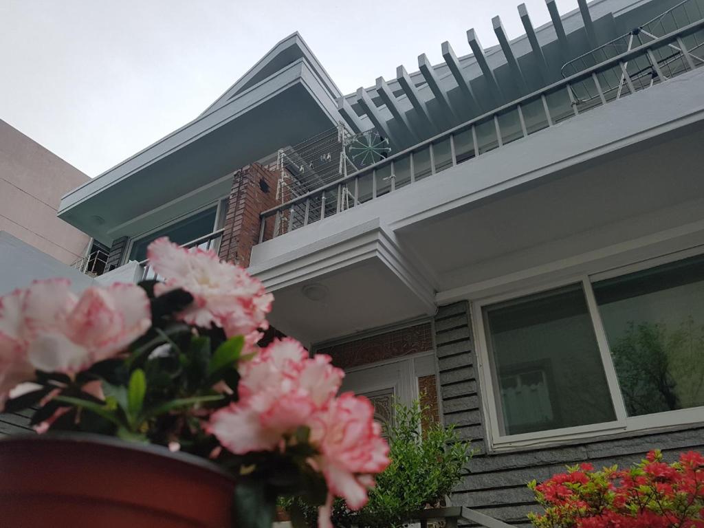 una casa con un jarrón de flores rosas delante en Byulbam Guesthouse, en Gwangju