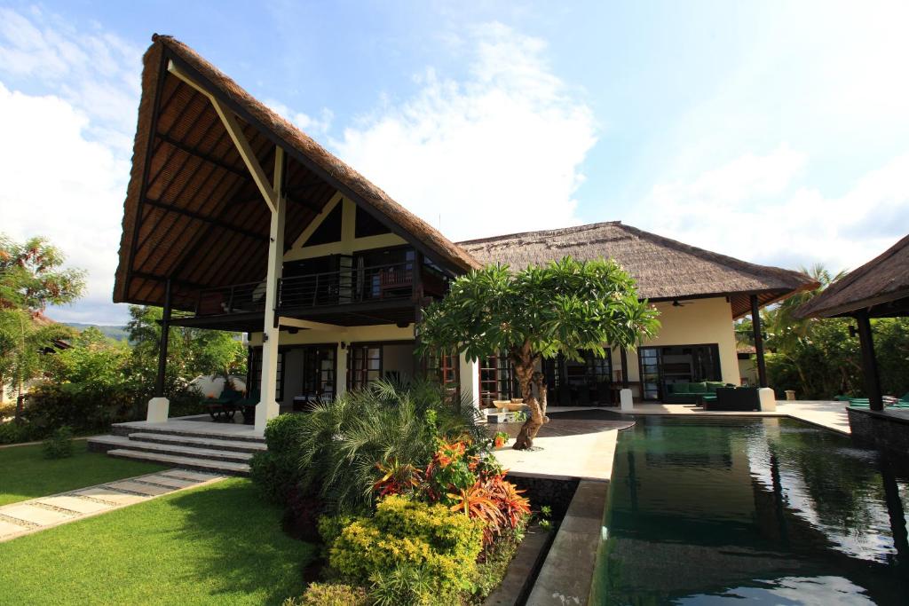 une maison avec un étang en face de celle-ci dans l'établissement Villa Baruna, à Banjar
