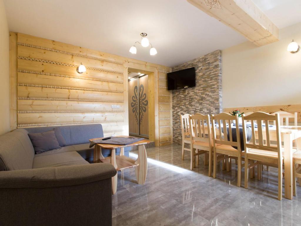 a living room with a couch and a table and chairs at Apartamenty Borysek De Lux in Białka Tatrzanska