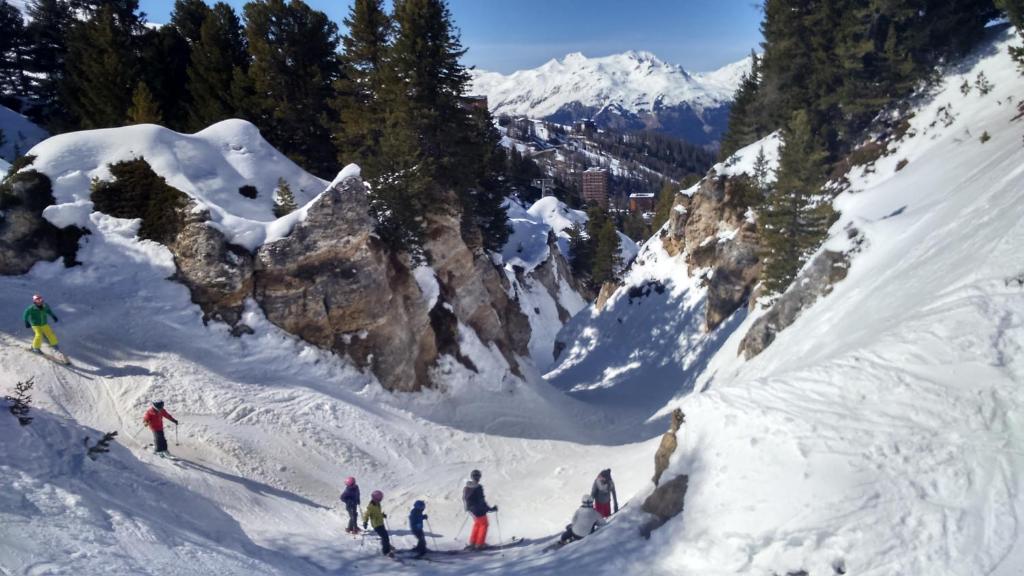 a group of people skiing down a snow covered mountain at Plagne Bellecote Apartments in Plagne Bellecote
