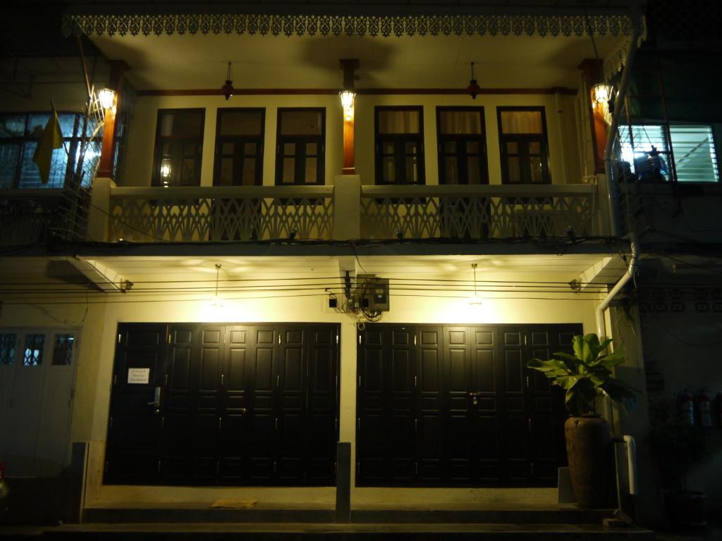 una casa con un garaje iluminado por la noche en The Royal ThaTien Village en Bangkok