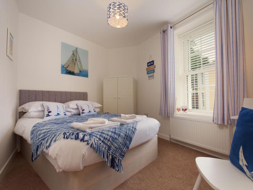 a bedroom with a bed with towels on it at The Bonting beautiful three bed townhouse near harbour and beach in Torquay
