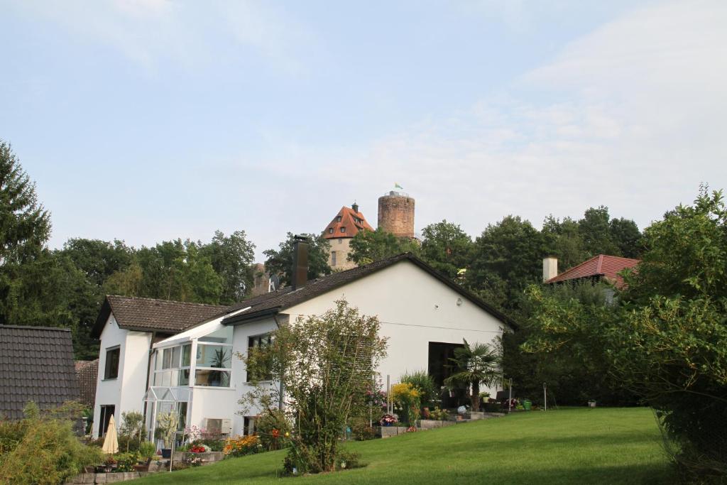 une maison blanche avec une cheminée en haut dans l'établissement Apartment mit Burgblick im Grünen, Familie Held, à Burgthann