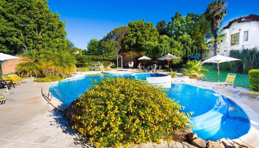 two swimming pools with yellow flowers in a resort at Hotel Palmar in Colón