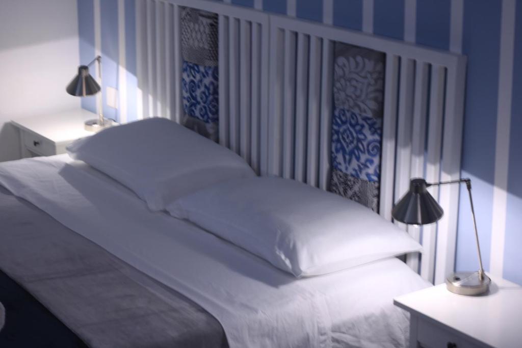 sypialnia z białym łóżkiem i 2 lampami w obiekcie Door Eight w mieście Floriana