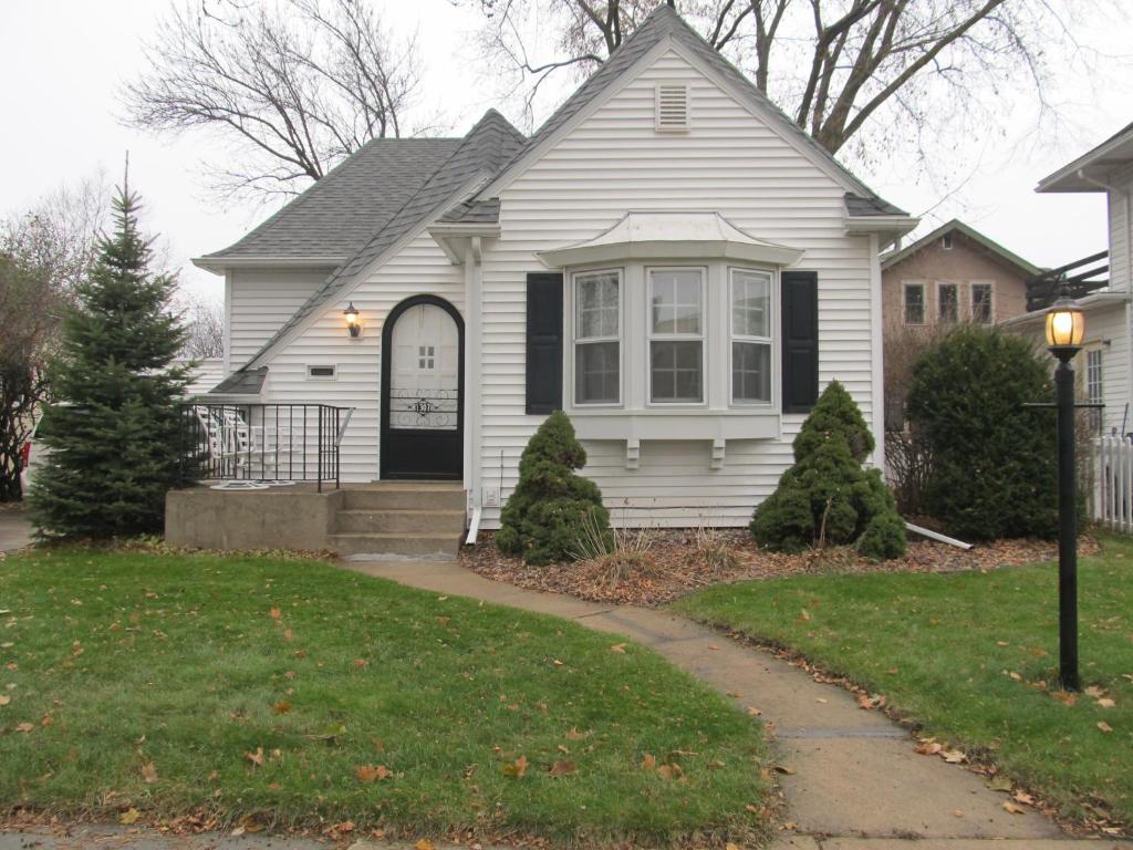 una casa bianca con una porta nera di Covered By Faith Rentals -Storybook Home a Rochester