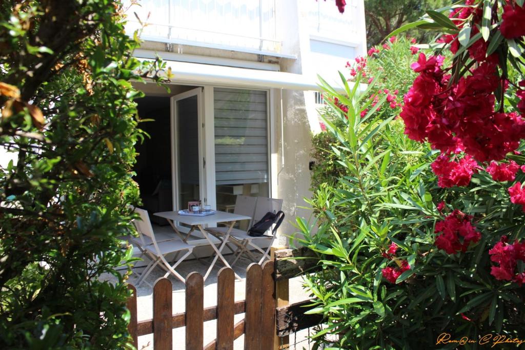 a patio with a table and chairs and flowers at Le flamant - Appartement P2 de 40m2 grande terrasse-parking-wifi in La Grande Motte