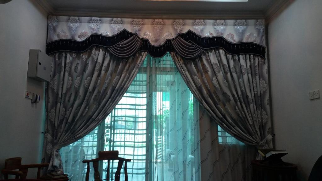 Cette chambre dispose d'une grande fenêtre avec des rideaux. dans l'établissement Villa Fairuz Hana Islamic Stay, à Kangar