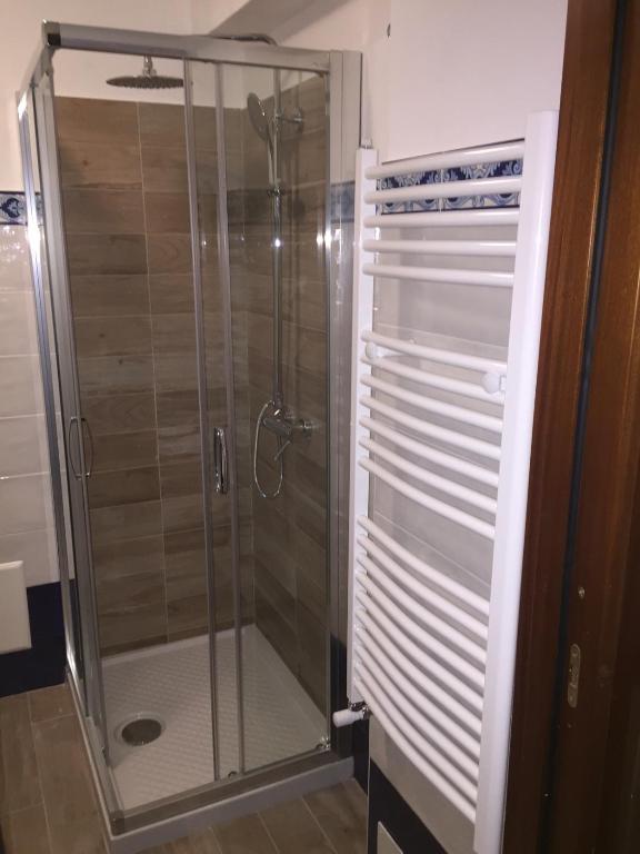W łazience znajduje się prysznic ze szklanymi drzwiami. w obiekcie B&B Lumasa w mieście Vietri sul Mare