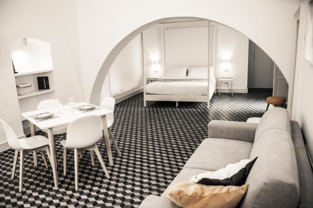 a living room with a couch and a table and a bed at MoMa Business Apartments in Molfetta