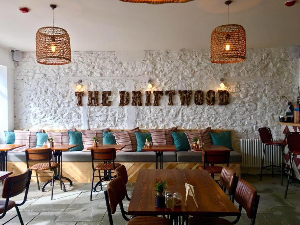 un restaurante con mesas y sillas y un sofá en The Driftwood en Sligo