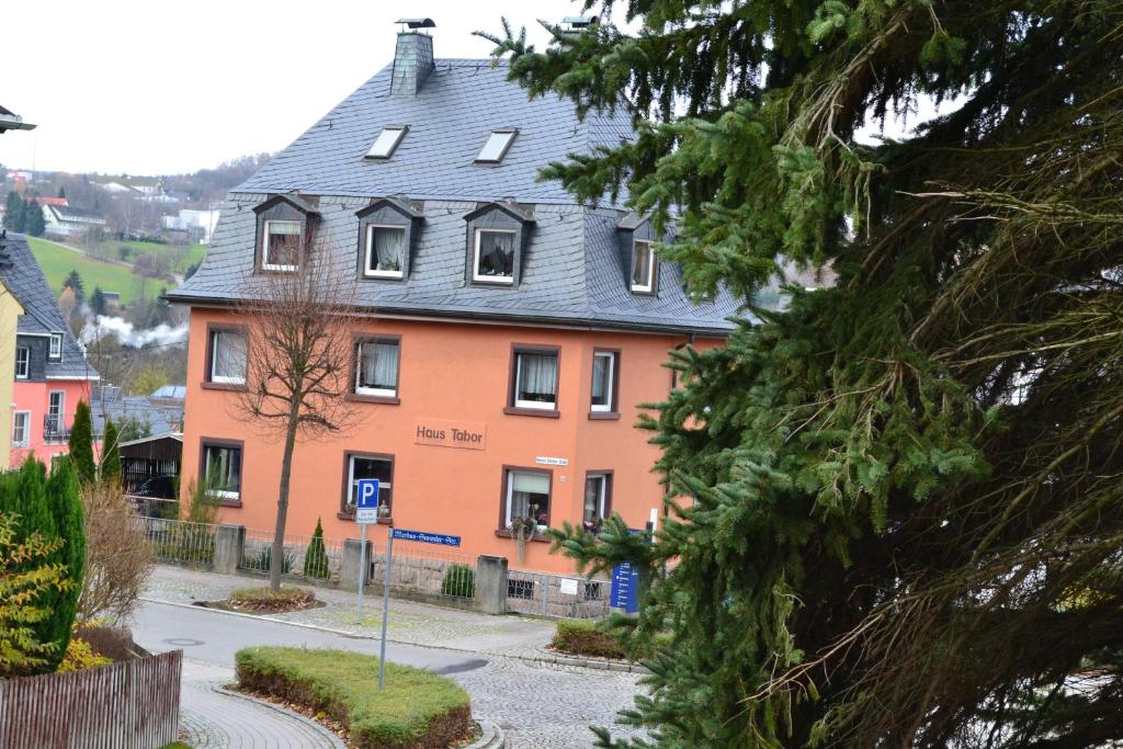 ein großes Haus mit grauem Dach auf einer Straße in der Unterkunft Haus "Tabor" in Bad Schlema