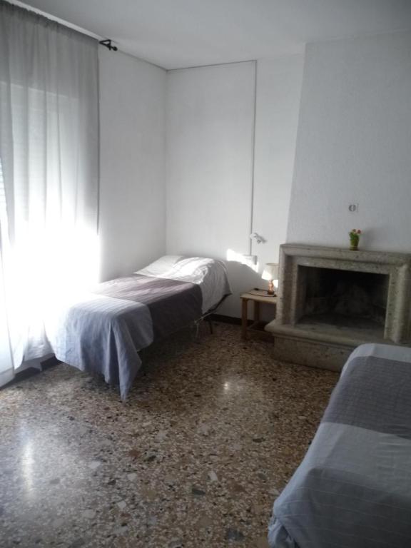 a white room with a bed and a fireplace at Appartamento Daniele in Mestre